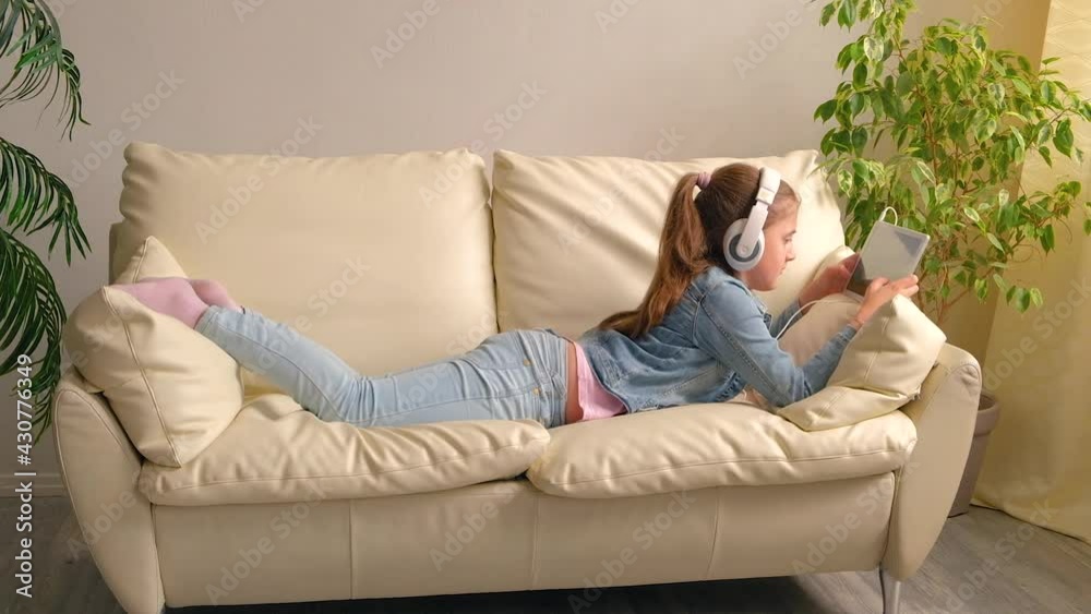 The child in the headphones with the tablet. T The child in the headphones with the tablet. T