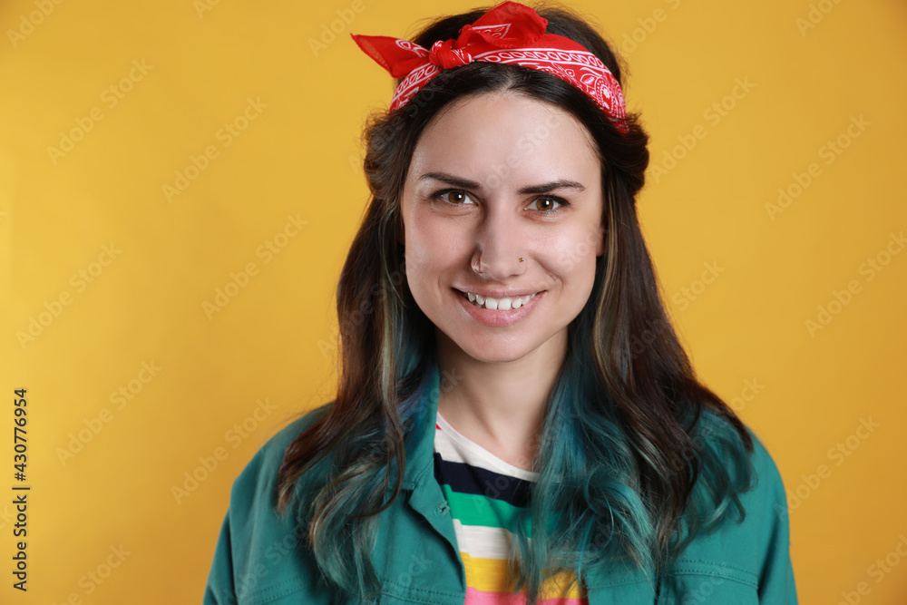 Beautiful young woman with nose piercing on yellow background Beautiful young woman with nose piercing on yellow background