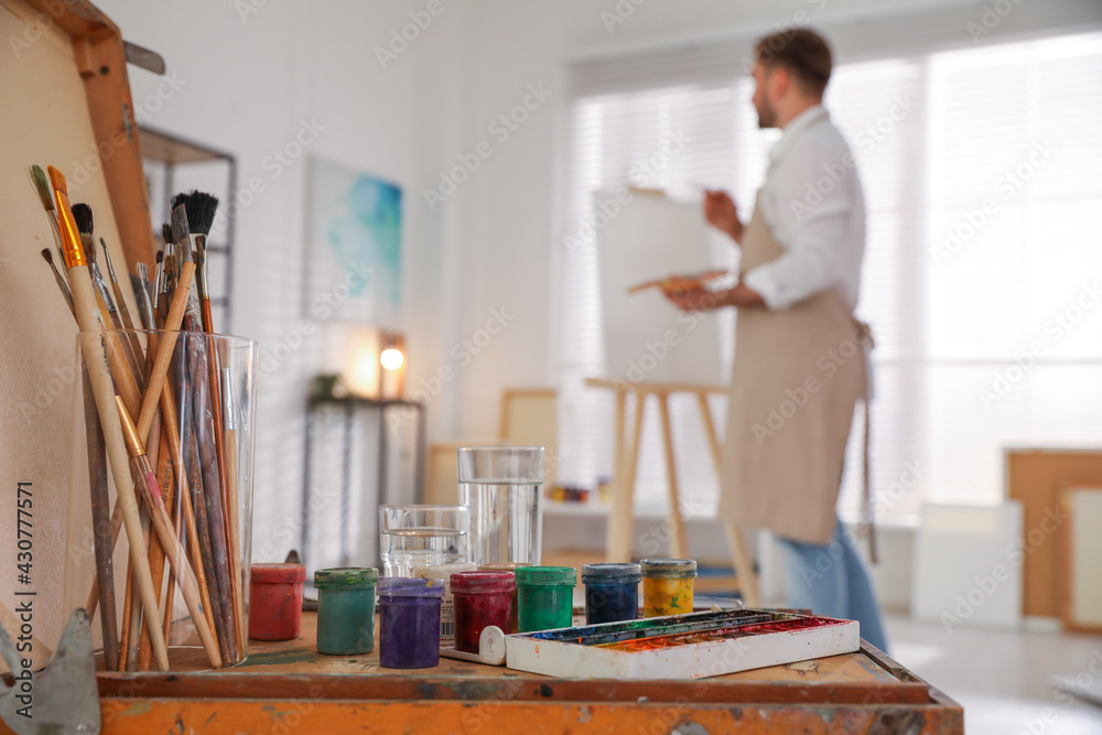 Man Using Art Tools Young man painting with brush in artist studio, focus on tools Stock ...