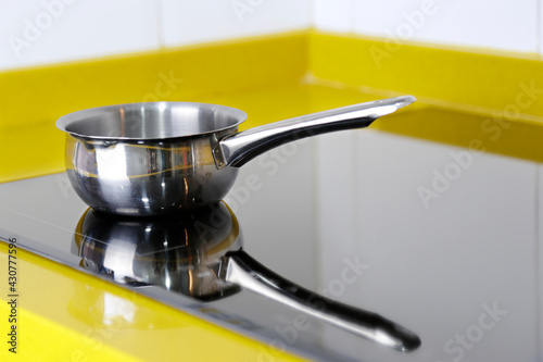 Little stainless steel pot in kitchen on the induction panel photo