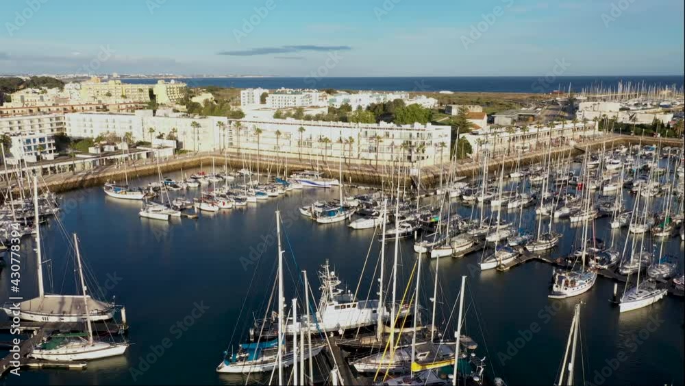 Aerial view of Lagos city center and marina. It shows the marina including boats on a sunny day with a blue sky in the background. Aerial view of Lagos city center and marina. It shows the marina including boats on a sunny day with a blue sky in the background.