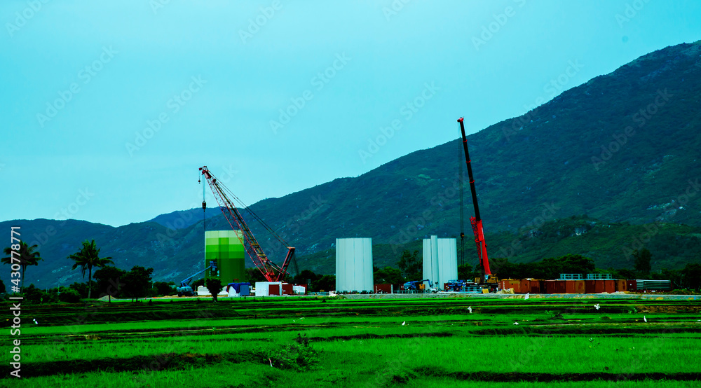 Fototapeta premium Wind Turbine Tower Construction On Sunny Day - Sustainable Investment