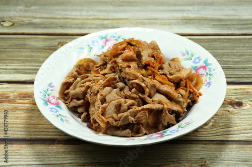 Classic fried and stirred pork meat with kimchi (Korea pickled vegetable) serving on the plate. Famous traditional menu in Asian restaurant. 