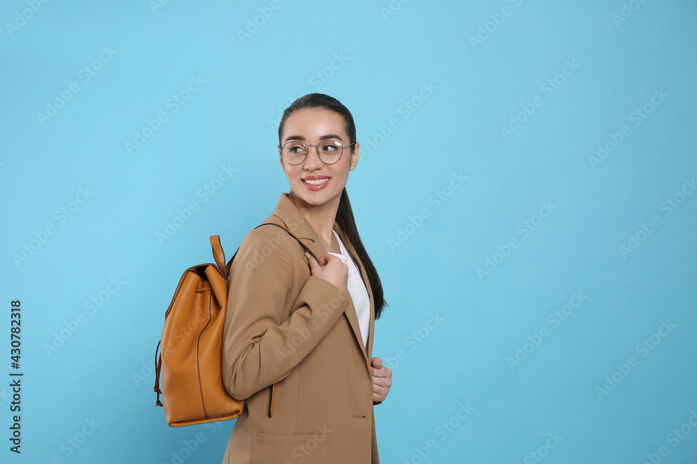 Beautiful young woman with stylish leather backpack on turquoise background. Space for text Beautiful young woman with stylish leather backpack on turquoise background. Space for text