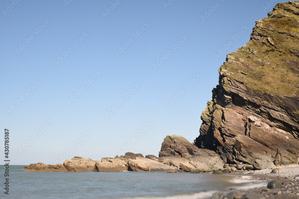 Cliff edge and rocks with waves from the ocean in landscape