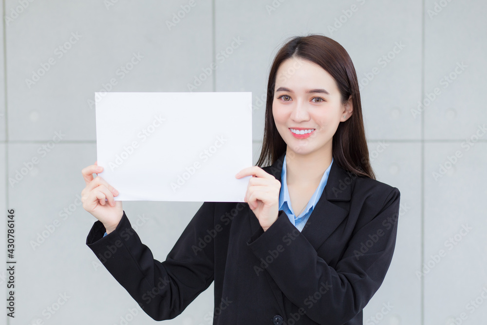 Asian business working woman holds plain paper (white paper) to present something. Asian business working woman holds plain paper (white paper) to present something.