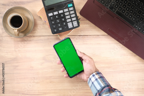 top view of man hand using smart phone on office desk  photo