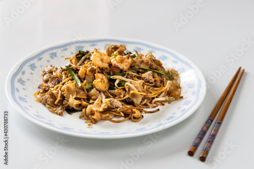Serving of simple penang char kuey teow is popular fried noodle with coceral, shrimp and eggs in black sauce in Malaysia photo
