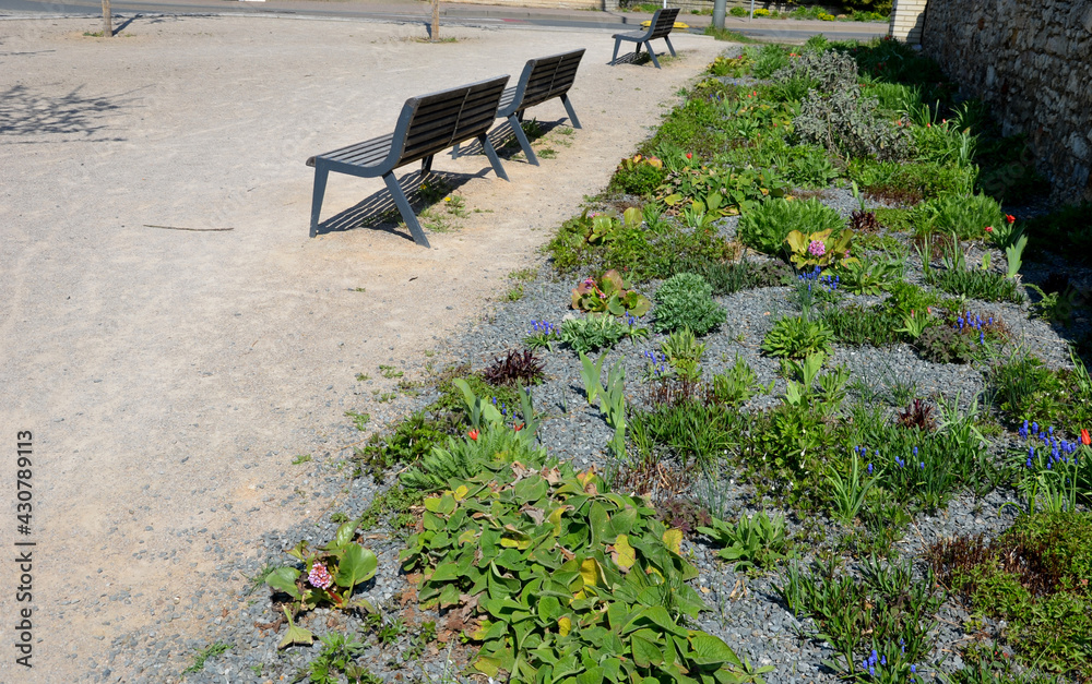 perennial bed mulched with gray gravel in front of a limestone stone ...