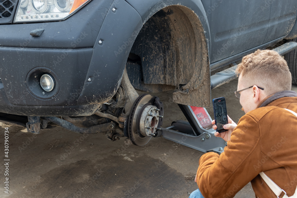 Fototapeta premium a man takes a photo of the brake disc of a car