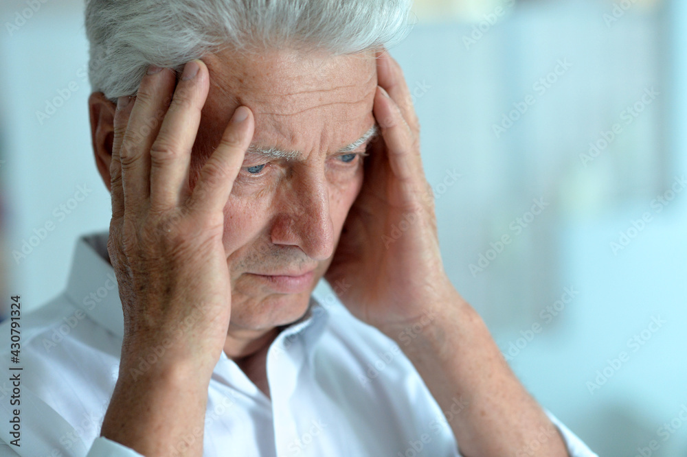 Portrait of sad sick senior man with  headache