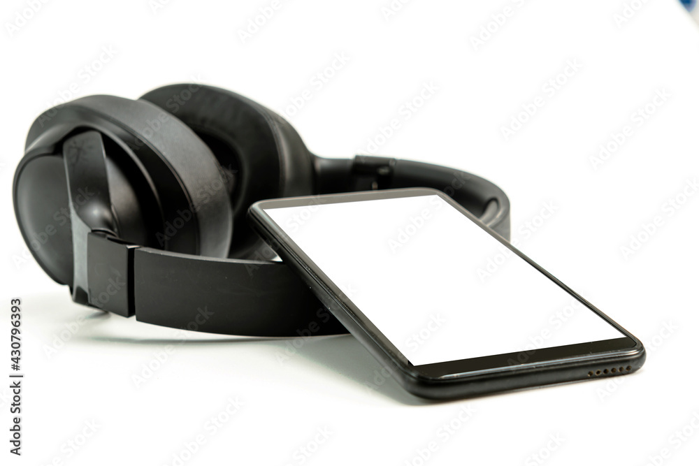 headphones with Bluetooth technology on white background, with black phone paired for music lovers headphones with Bluetooth technology on white background, with black phone paired for music lovers