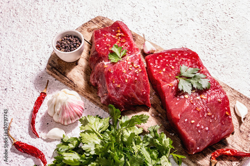 Raw beef steaks on a wooden cutting board