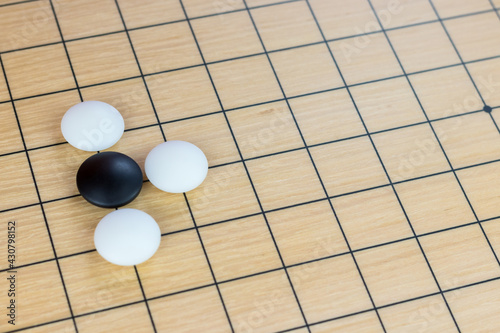 Training simple position of black and white stones on the playing field (gohan) of traditional Chinese strategy game go
