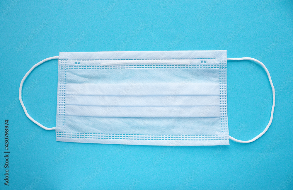 White medical mask on blue background White medical mask on blue background
