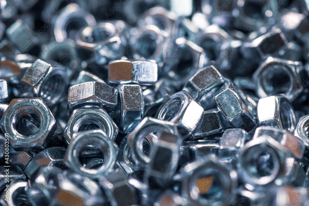 Metal chrome nuts in a chaotic order industrial background Metal chrome nuts in a chaotic order industrial background