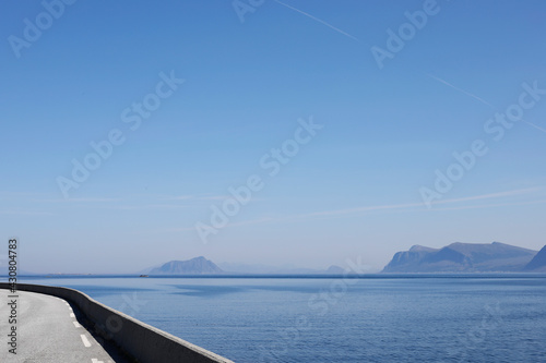 Nordic fjord seascape and landscape from the edge of a road, blue sky, mountains and islands, wilderness