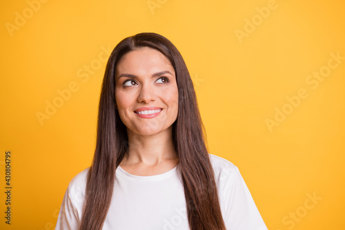 Photo portrait of dreamy brunette woman smiling looking copyspace in white clothes isolated on vivid yellow color background