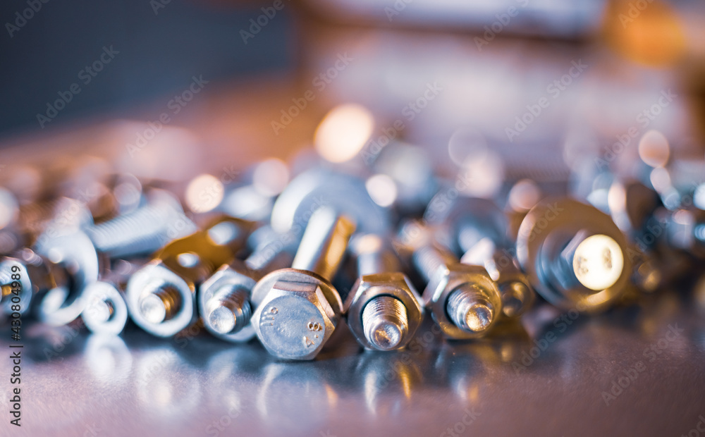 Metal chrome bolts and nuts in a chaotic order industrial background Metal chrome bolts and nuts in a chaotic order industrial background