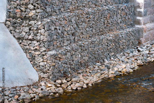 Bridge abutment with gabions. Gabion wall constructed using steel wire mesh basket. Stone walls, protection from backshore erosion. Gabion and rock armour - coastal and waterways protection. photo