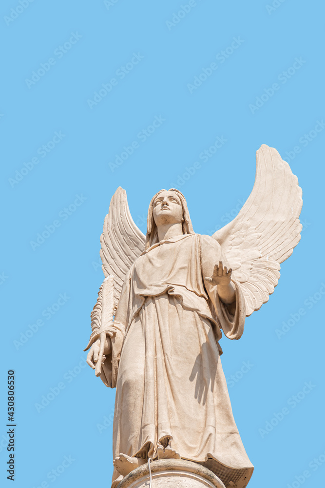 Obraz premium Cover page with statue of winged angel at Evangelical church Saint Nikolai with copy space for text and blue sky as solid background, Potsdam, Germany. Concept of religious and historical heritage.