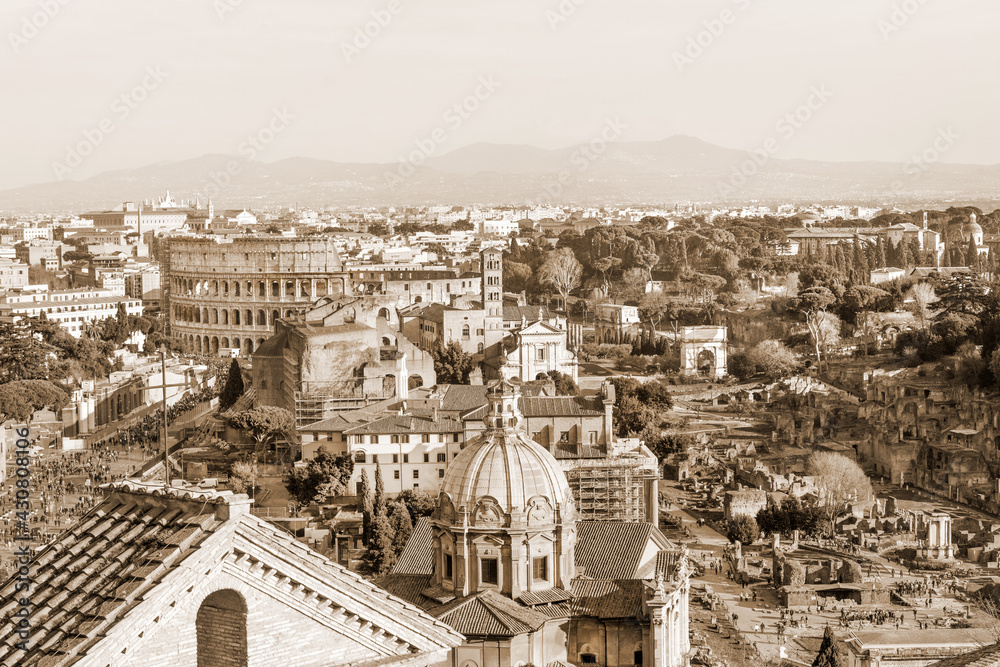 Aerial panorama of Roman Forum ruins and Colosseum in sepia, Rome, Italy