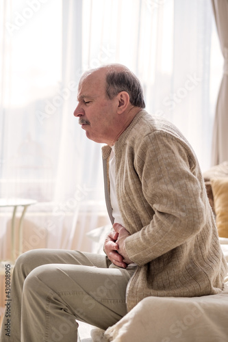 Senior man having stomach pain sitting home © Viktor Koldunov