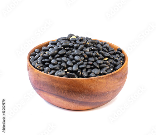 Black beans in wooden bowl on white background