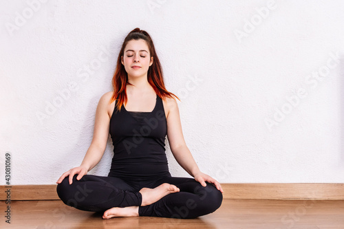 woman practices yoga and meditates in the lotus position