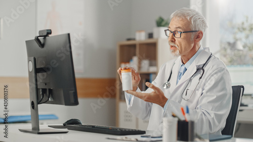 Doctor's Online Medical Consultation: Caucasian Senior Physician is Making a Conference Video Call with a Patient on a Computer. Health Care Professional Giving Advice, Explaining Test Results.