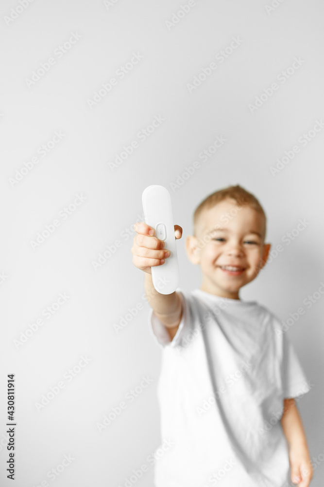 measure the boy's temperature in case of illness with an electronic thermometer on white background measure the boy's temperature in case of illness with an electronic thermometer on white background