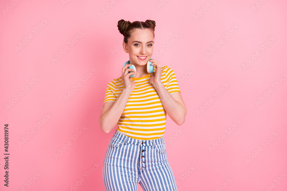 Photo of pretty lady arms touch headphones on neck beaming smile look camera isolated on pink color background Photo of pretty lady arms touch headphones on neck beaming smile look camera isolated on pink color background