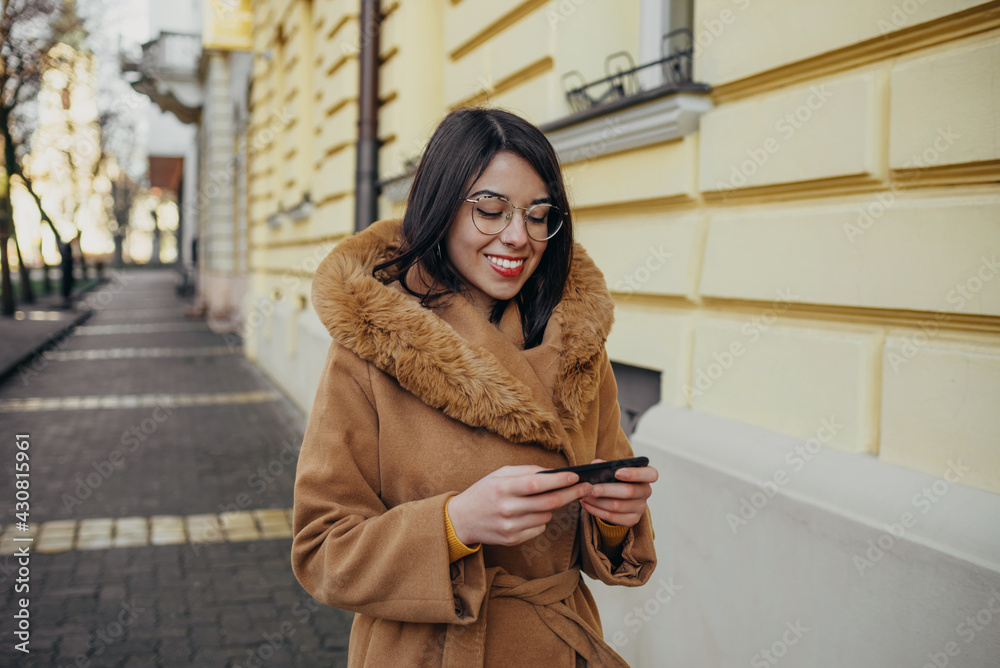 Young happy Hispanic woman using a smartphone Young happy Hispanic woman using a smartphone