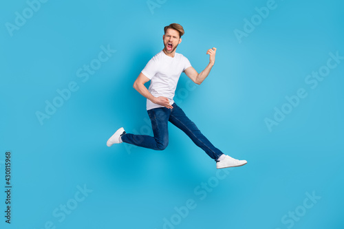 Full body photo of young person open mouth shout loud hands play guitar isolated on blue color background