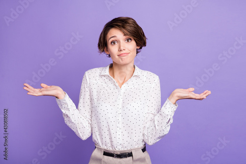 Portrait of attractive unsure girl executive manager shrugging shoulders isolated over bright violet purple color background