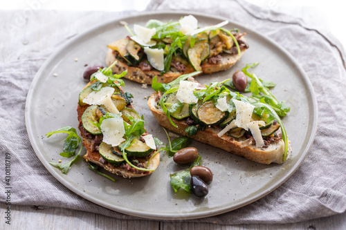 Vegetarian bruschette with olives and courgettes