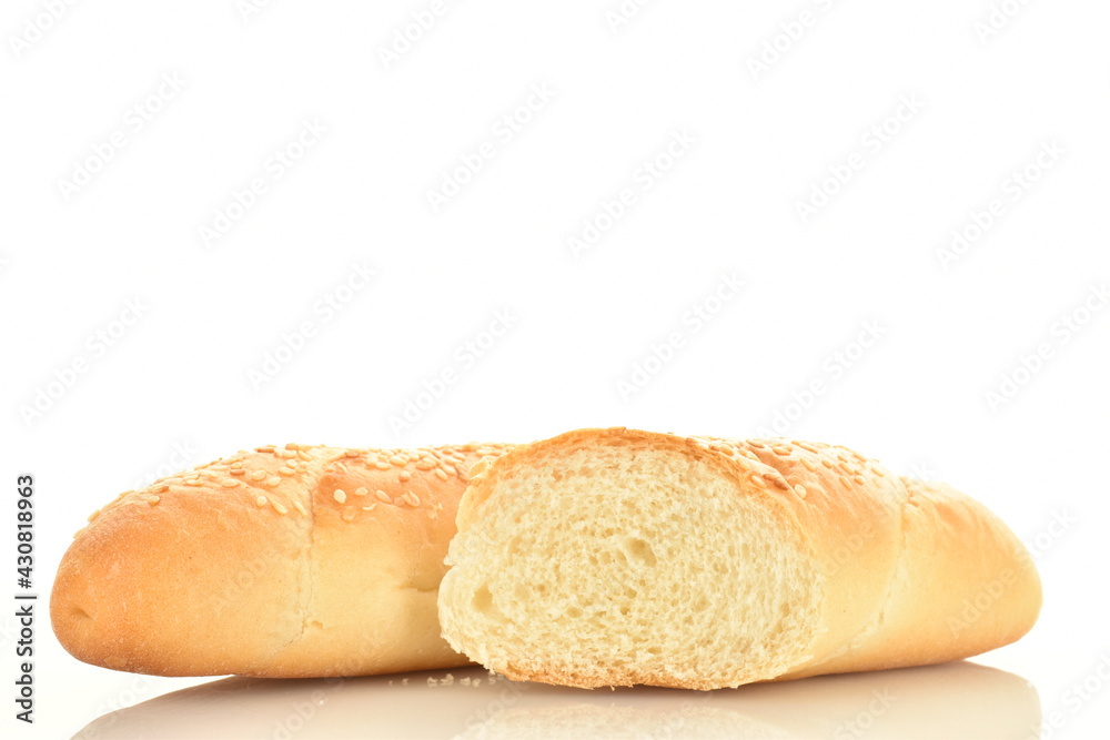 One whole and one half fragrant bagels sprinkled with sesame seeds in a black ceramic plate, close-up, isolated on white.