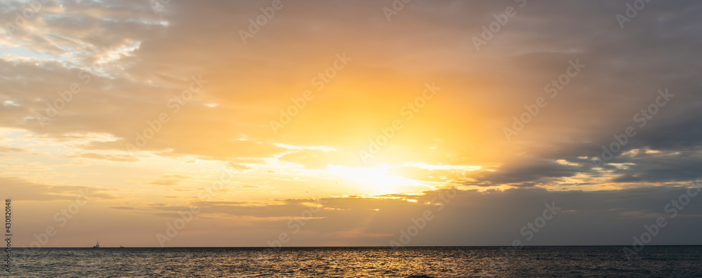 Boat sailing under a shining sun at sunset