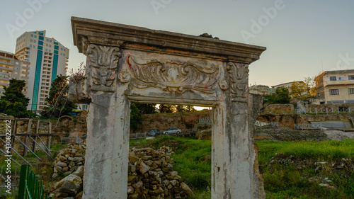 DURRES, ALBANIA: Exterior of ancient Roman amphitheater with surrounding buildings in the city of Durres. photo