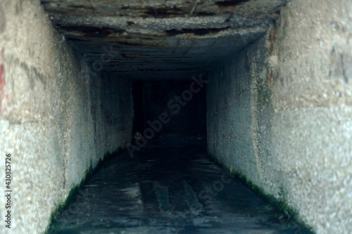 A dark deep manmade hole inside a concrete wall. Ominous, disquieting feeling.  © Grenar