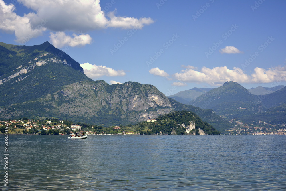 Italy Lierna, June 23 2018. Horizontal panorama of fresh lake Como surrounded by hills covered with green cedar forest