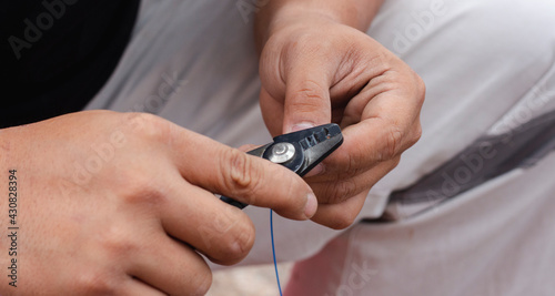 The technician cuts the fiber optic cable using a variety of fiber cleaver tools and the cable is connected with a fultion splice to ensure a stable signal connection.