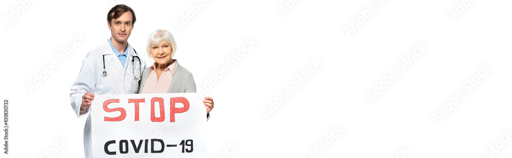 Senior patient and doctor holding placard with stop covid-2019 lettering isolated on white, banner Senior patient and doctor holding placard with stop covid-2019 lettering isolated on white, banner