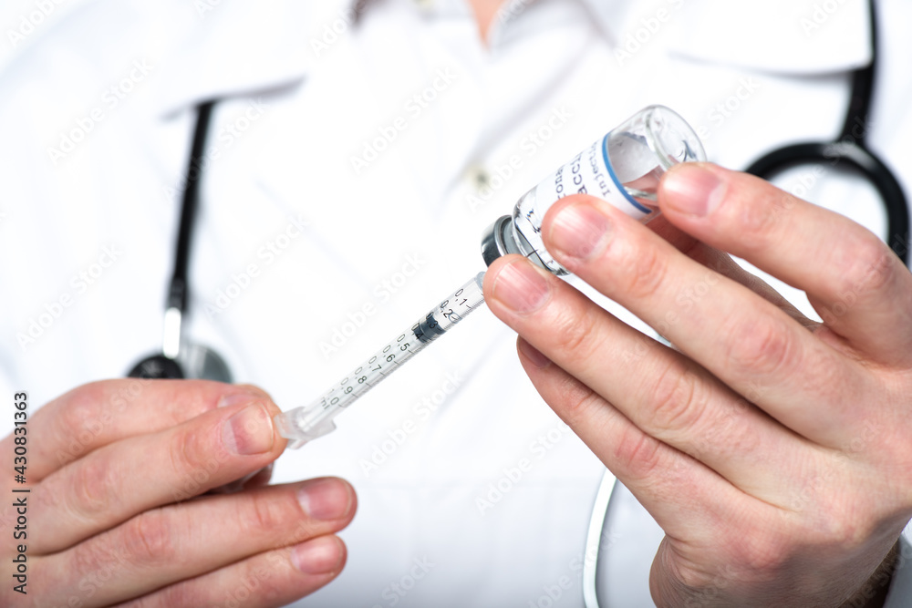 Cropped view of blurred doctor piking up vaccine in syringe isolated on white Cropped view of blurred doctor piking up vaccine in syringe isolated on white