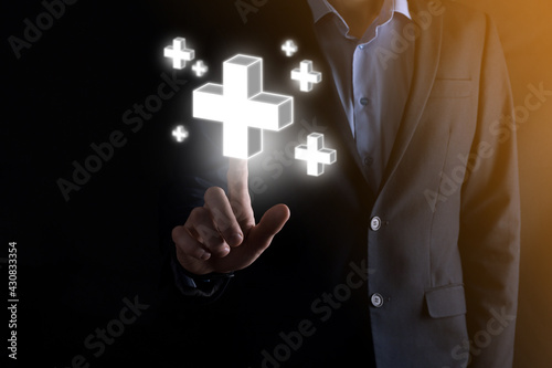 Businessman hold 3D plus icon, man hold in hand offer positive thing such as profit, benefits, development, CSR represented by plus sign.The hand shows the plus sign