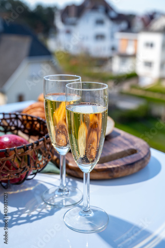 Drinking of brut champagne sparkling wine in flute glasses on outdoor bistro terrace in France