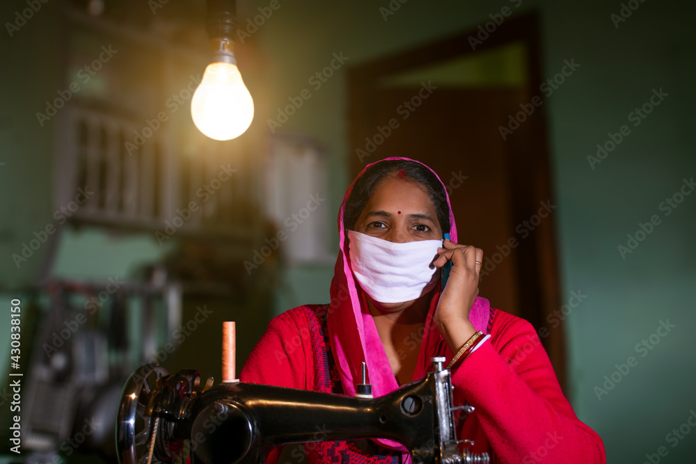 PORTRAIT OF A RURAL WOMAN WEARING MASK and talking on a mobile phone PORTRAIT OF A RURAL WOMAN WEARING MASK and talking on a mobile phone