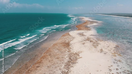 Aerial view of ocean coastline and barrier reef at Low Tide, Zanzibar, Matemwe. Shallows near the coral reef with tidal waves. Paradise landscape of tropical shore. East coast of Unguja island, Africa photo