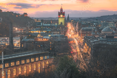 Illuminated cityscape view of Edinburgh old town skyline, Princes Street traffic, Balmoral Clock Tower, Edinburgh Castle and city lights from Calton Hill, Scotland.