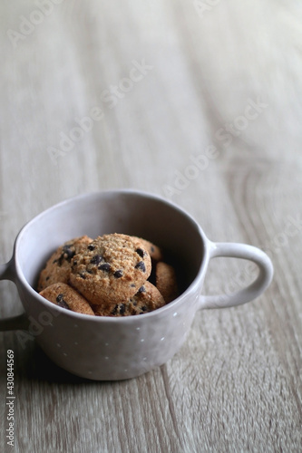 Bowl of chocolate chip cookies on wooden table. Selective focus.